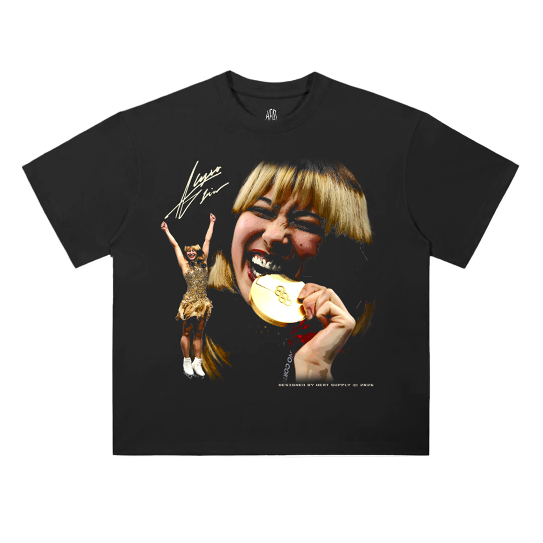 Black oversized drop shoulder T-shirt featuring a bold graphic of Alysa Liu biting a gold medal with a smaller celebratory figure pose and signature detail on the front, heavyweight cotton unisex loose fit tee.