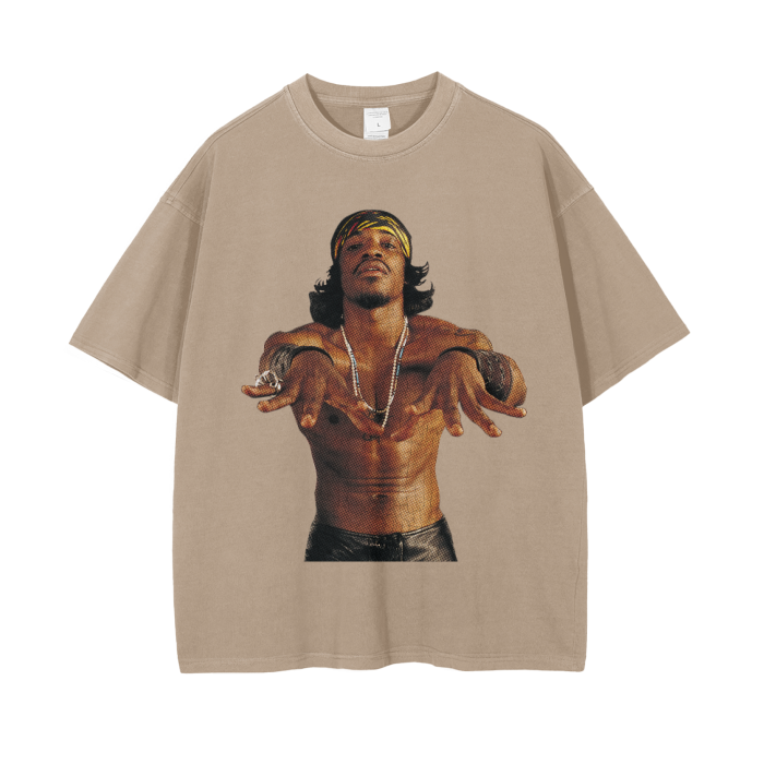 Khaki-colored oversized t-shirt featuring a large image of André 3000, shirtless, with a confident pose and wearing a headband, necklaces, and bracelets. The image captures his distinctive style and charismatic personality.
