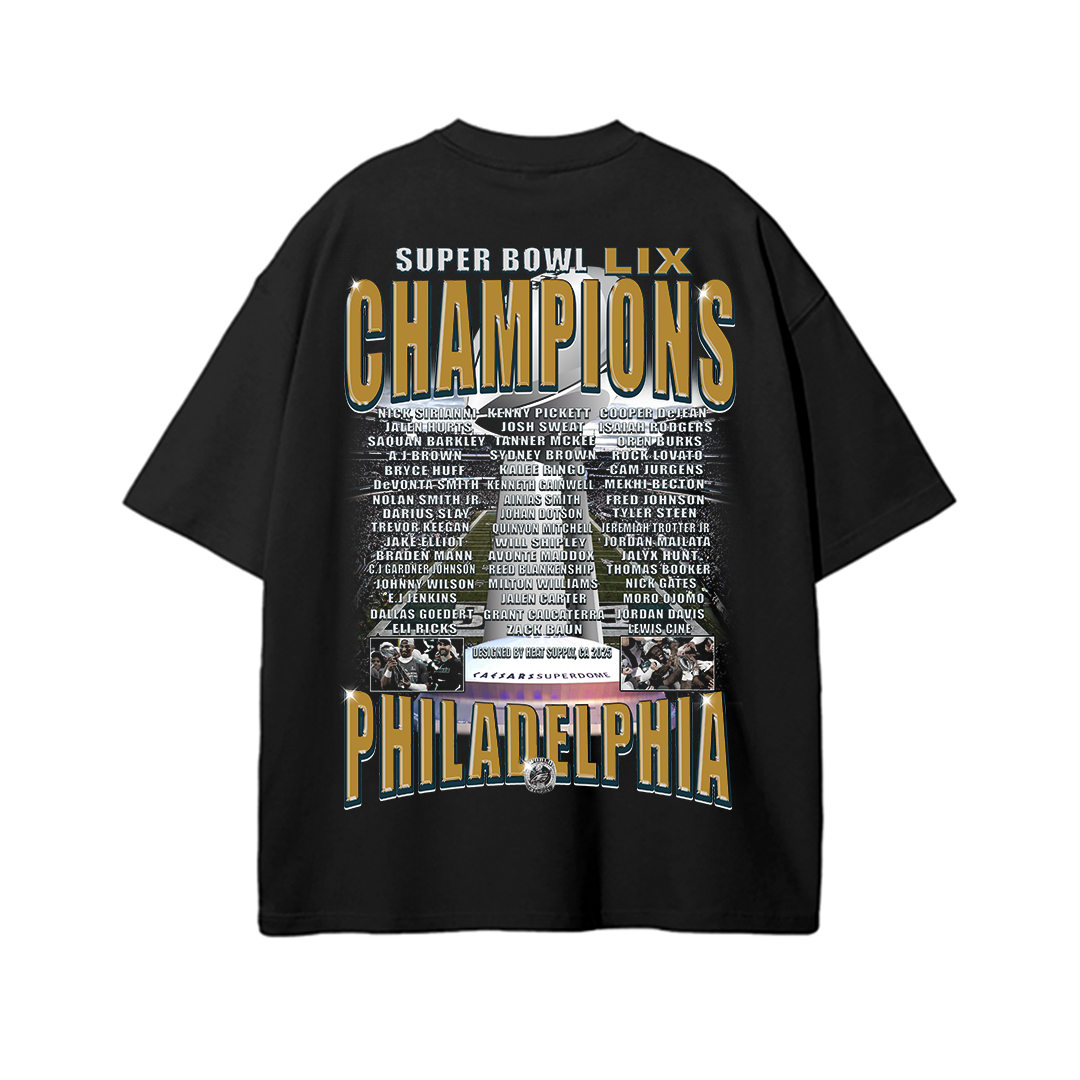 Black oversized drop-shoulder T-shirt featuring 'SUPER BOWL LIX CHAMPIONS' in bold gold and navy lettering across the top. Below, the full Eagles team roster is listed, centered around an image of the championship celebration and 'PHILADELPHIA' in large capital letters at the bottom, making it a statement piece for Eagles fans