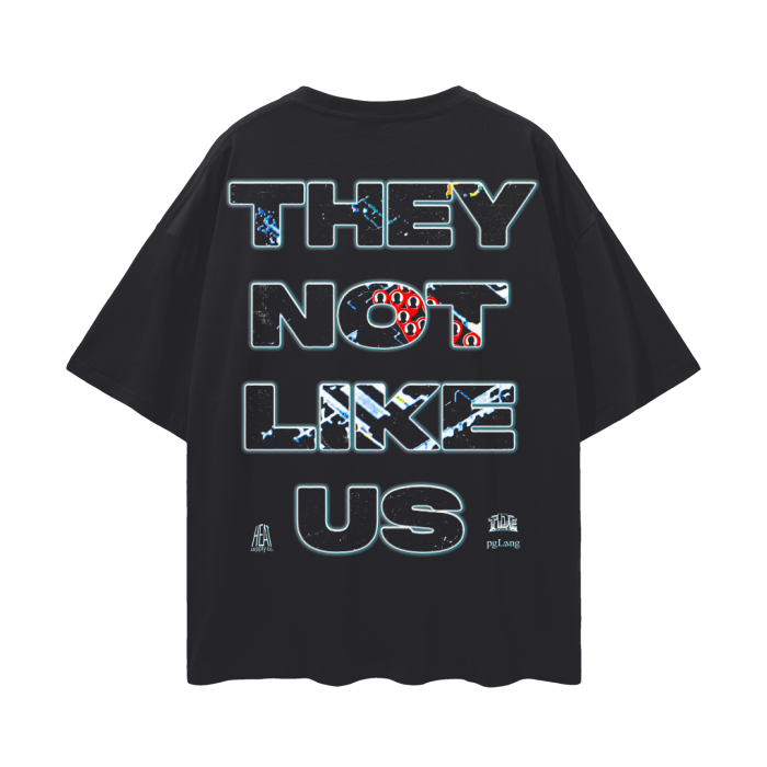 The back of a black oversized tee with bold text reading 'THEY NOT LIKE US' in large, futuristic letters with abstract designs within the text.