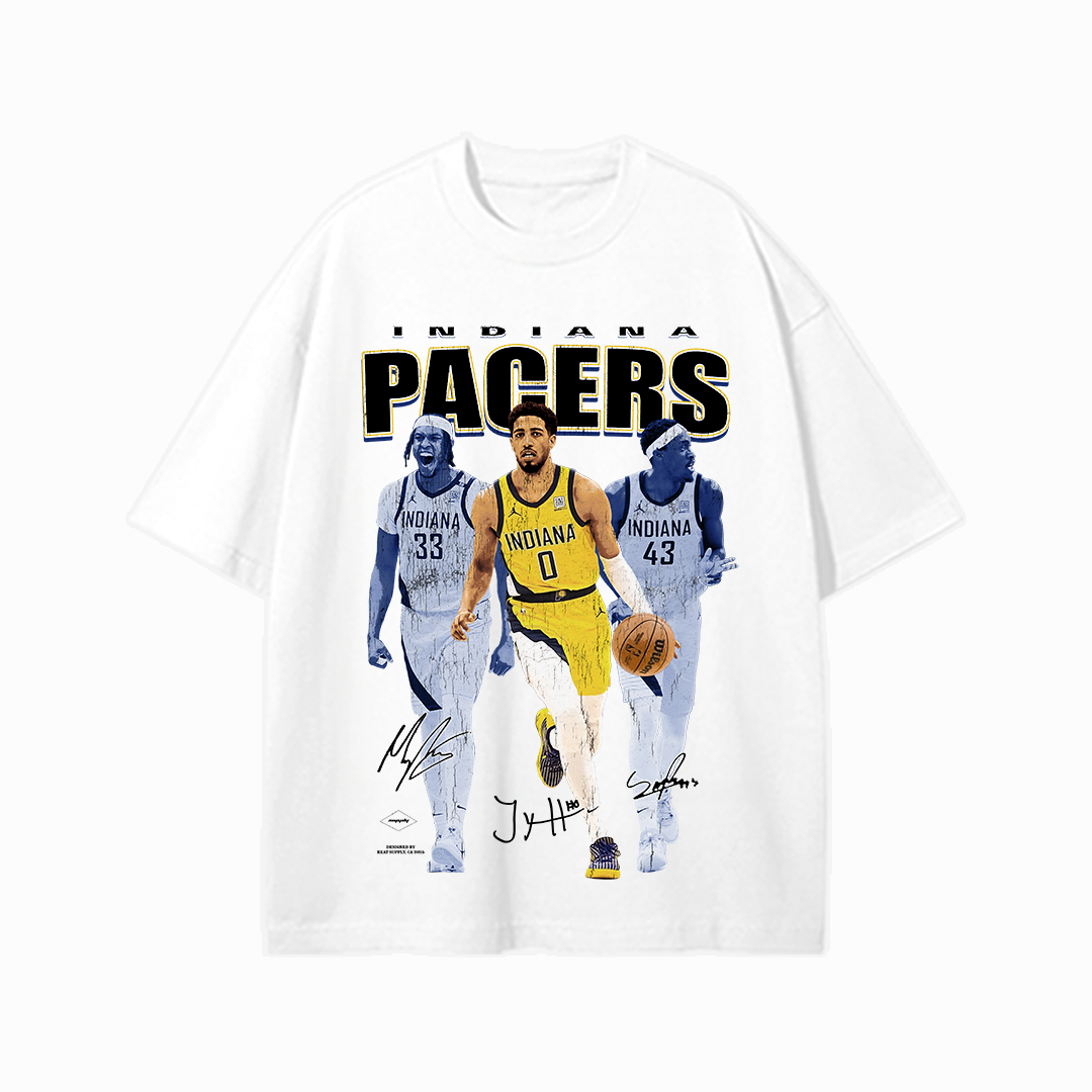 White unisex t-shirt featuring Tyrese Haliburton in full color dribbling a basketball, flanked by monochrome images of Myles Turner and Pascal Siakam, with bold “INDIANA PACERS” text above and player signatures below.
