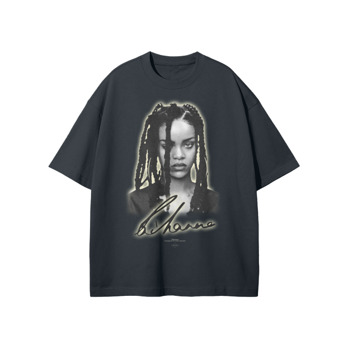 A grey oversized t-shirt featuring a grayscale portrait of Rihanna with her signature below. The design has a soft glow effect around the portrait, adding a subtle highlight to the image.