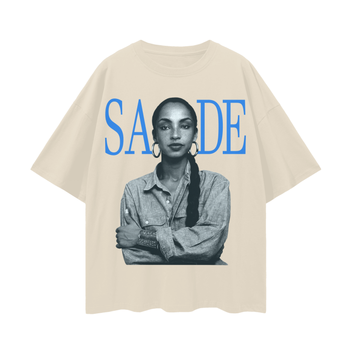 A khaki oversized t-shirt featuring a black and white image of the iconic artist Sade, with her name "SADE" displayed in bold blue letters above the portrait