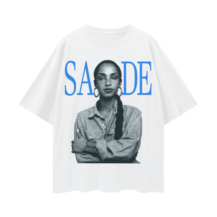 A white oversized t-shirt featuring a black and white image of the iconic artist Sade, with her name "SADE" displayed in bold blue letters above the portrait