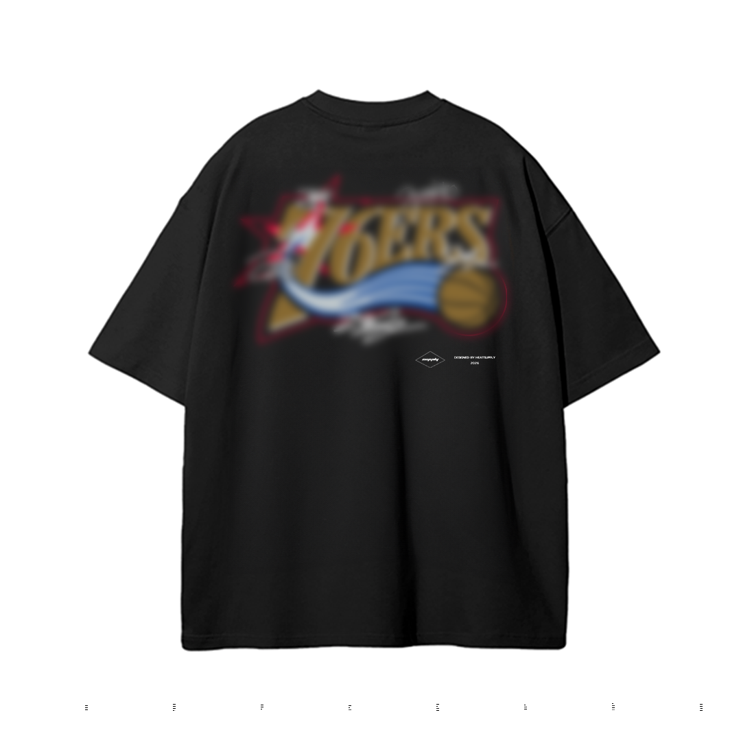 Black oversized graphic T-shirt featuring a large retro-inspired SIXERS design with gold lettering, red outlines, blue swoosh graphics, a basketball illustration, and white signature-style accents.