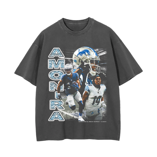 Grey oversized t-shirt with images of Amon-Ra St. Brown in various action poses as a wide receiver for the Detroit Lions. The text 'AMON-RA' is printed vertically on the left, with the Detroit Lions helmet and logo included
