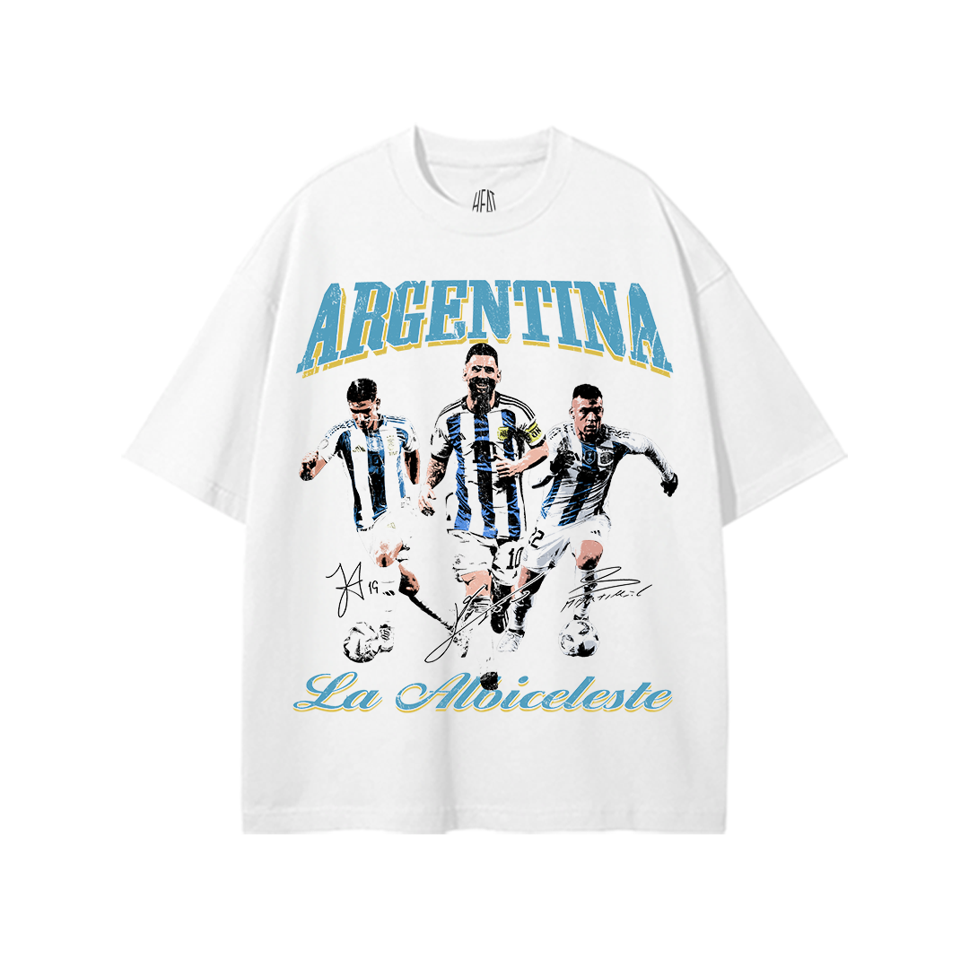 White heavyweight Argentina soccer graphic tee featuring vintage-style La Albiceleste artwork with multiple Argentina football player graphics and blue-and-gold “Argentina La Albiceleste” typography.