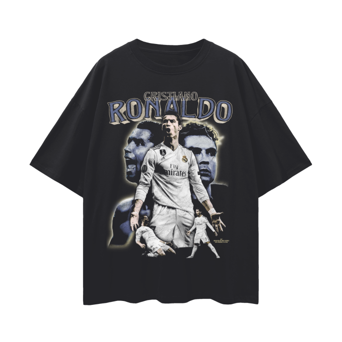 A black oversized T-shirt featuring a collage design of Cristiano Ronaldo, with the text "El Rey de Madrid" and "Máximo Goleador Histórico del Real Madrid." The design includes a large image of Ronaldo heading a ball, a smaller image of him celebrating a goal, and a series of smaller images of him playing and celebrating with his teammates.