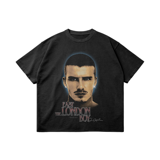 A black oversized T-shirt with a large portrait of a young David Beckham, highlighting his face with a short haircut and mustache, accompanied by the text "East London Boy" in a vintage font