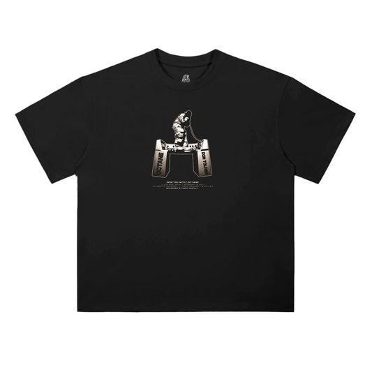 Black oversized heavyweight T-shirt featuring a small centered graphic of a Don Toliver standing on a recording studio equipment labeled “Octane” and “Don Toliver,” with minimal white text beneath.