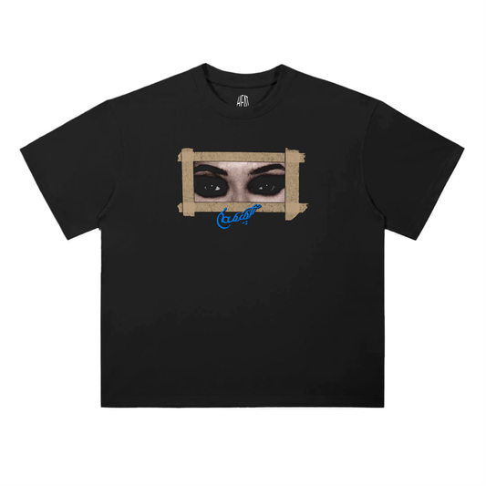Black oversized drop-shoulder T-shirt featuring a front graphic of eyes framed with tape and a small script detail, with a large back design combining layered eye imagery, blue script text, and tracklist-style typography inspired by Drake/Iceman aesthetics.