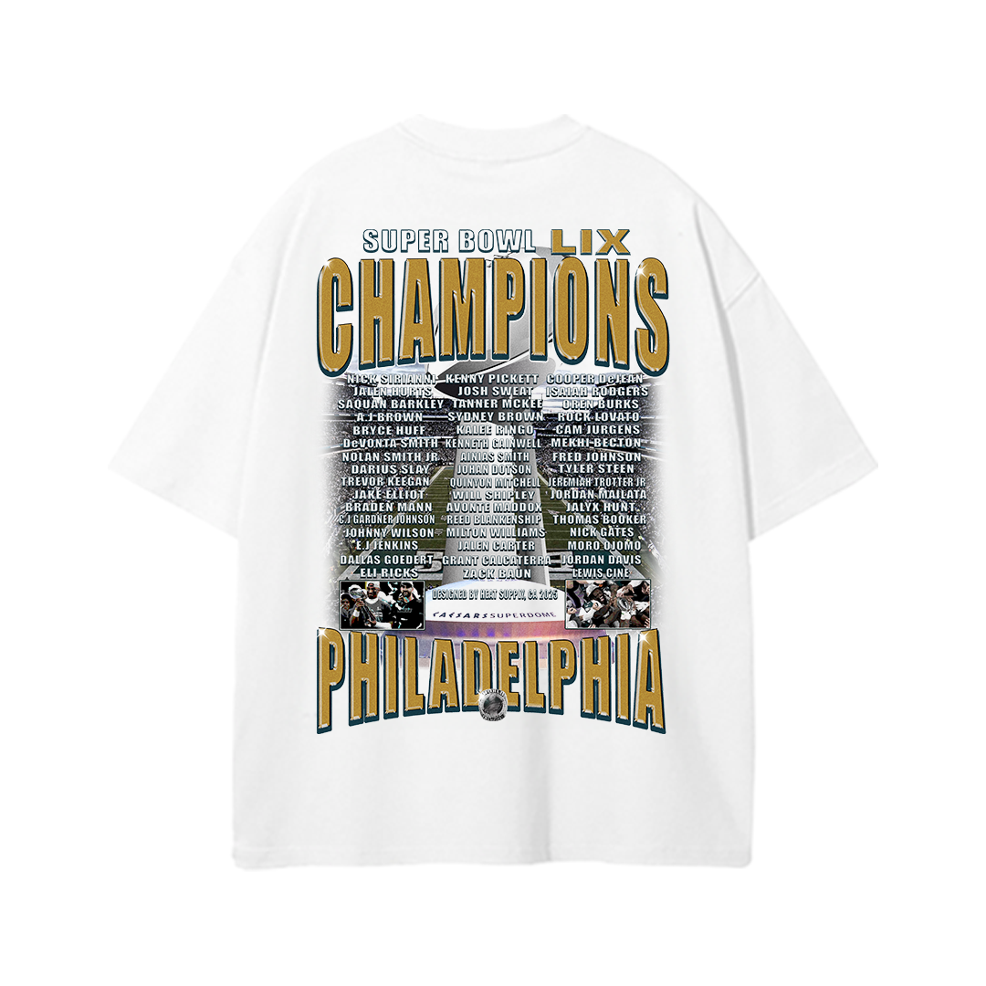 White oversized drop-shoulder T-shirt featuring 'SUPER BOWL LIX CHAMPIONS' in bold gold and navy lettering across the top. Below, the full Eagles team roster is listed, centered around an image of the championship celebration and 'PHILADELPHIA' in large capital letters at the bottom, making it a statement piece for Eagles fans