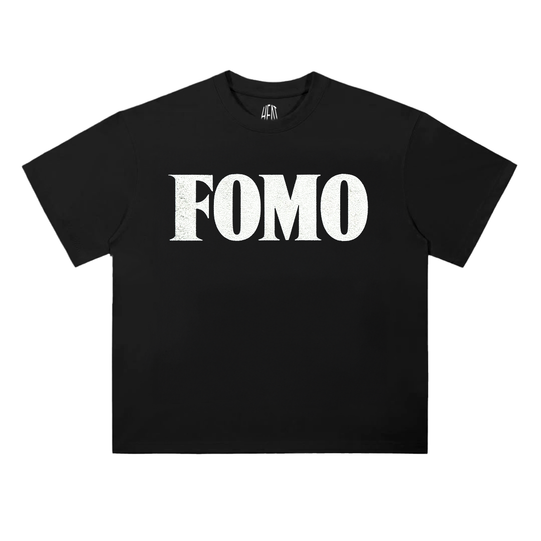 White heavyweight cotton T-shirt featuring a minimalist "FOMO" chest graphic on the front and a bold oversized "Fear Of Missing Out" typography design across the back, inspired by modern hip-hop streetwear aesthetics.