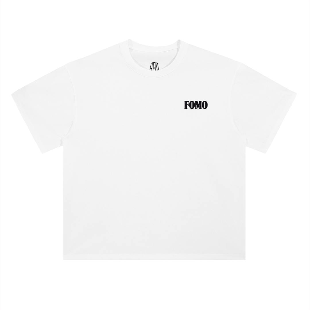 White heavyweight cotton T-shirt featuring a minimalist "FOMO" chest graphic on the front and a bold oversized "Fear Of Missing Out" typography design across the back, inspired by modern hip-hop streetwear aesthetics.