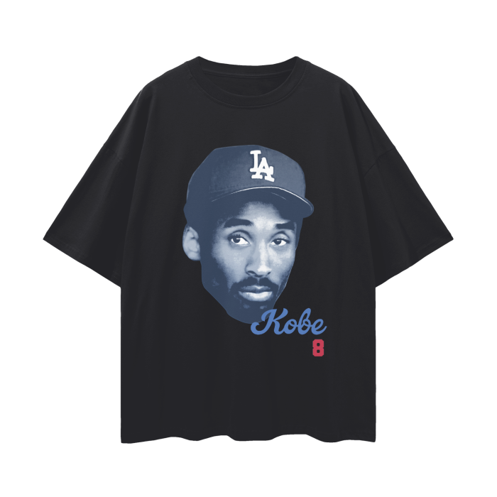 A black oversized t-shirt featuring a large, monochromatic image of Kobe Bryant wearing an LA Dodgers baseball cap. The shirt has a minimalist design with the name "Kobe" in blue cursive and the number "8" in red beneath the image.