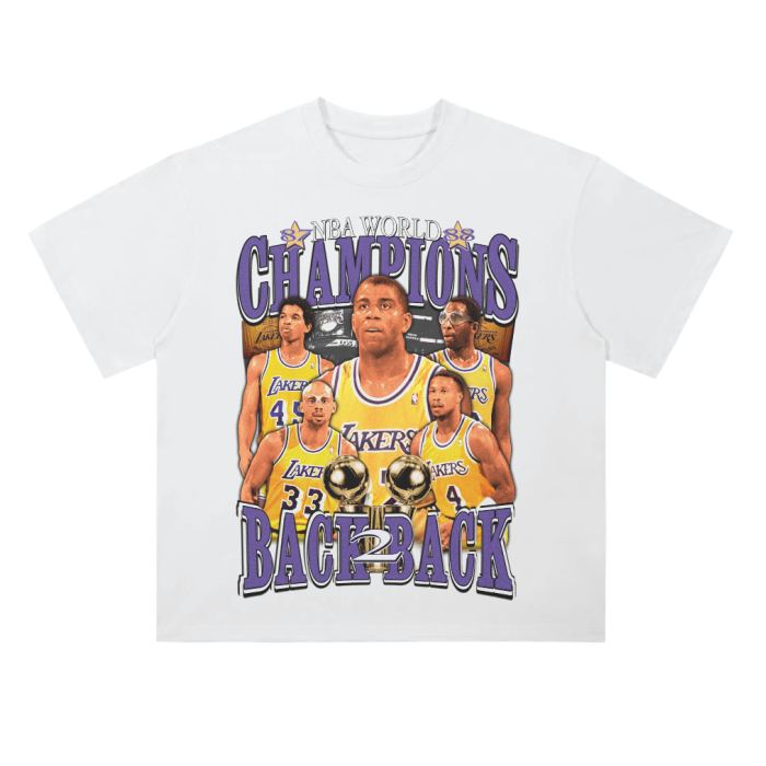 A white t-shirt featuring a retro design celebrating the Los Angeles Lakers' back-to-back NBA championships. The front of the t-shirt highlights the key players, including Magic Johnson and Kareem Abdul-Jabbar, with the phrase 'NBA World Champions' above and 'Back to Back' below. The design is done in purple and gold, with the players shown holding two championship trophies