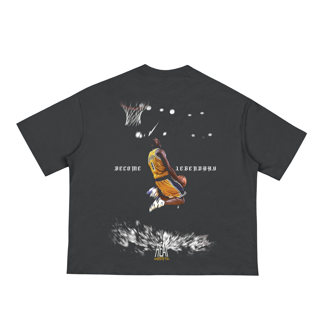 Black unisex t-shirt featuring a graphic of Kobe Bryant in a gold Lakers jersey mid-air for a dunk, with “BECOME LEGENDARY” text and the Heat Supply Co. logo beneath the design.