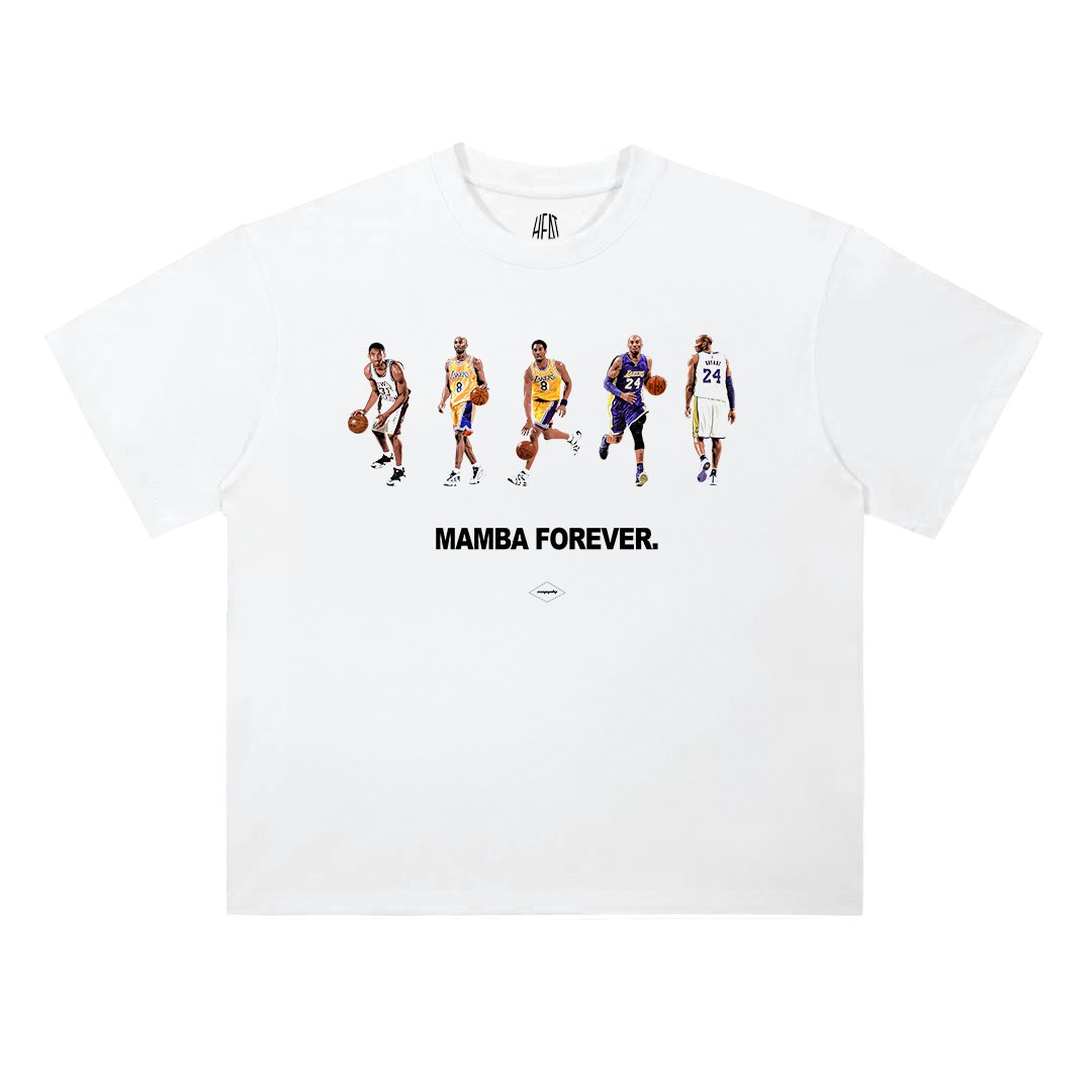 White heavyweight standard-fit cotton T-shirt featuring a minimalist front graphic of Kobe Bryant throughout different stages of his Lakers career above the bold "Mamba Forever" text. The clean design pays tribute to the legendary NBA icon with a timeless basketball-inspired aesthetic.