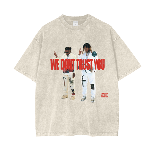 A beige acid-wash oversized T-shirt featuring images of Metro Boomin and Future in stylish outfits. The text "WE DON'T TRUST YOU" appears in bold red letters across the chest, with a "Parental Advisory" label in the bottom right corner. The T-shirt has a vintage, streetwear vibe