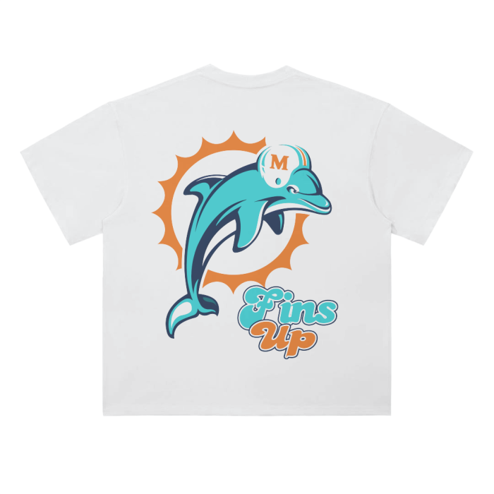 A white heavyweight drop shoulder t-shirt featuring a large retro-style Miami Dolphins logo with a stylized dolphin in a helmet, surrounded by an orange sunburst, and the text "Fins Up" in teal and orange at the bottom.