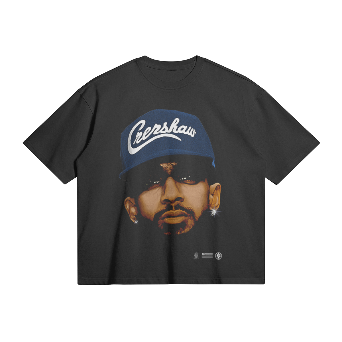 A black oversized heavyweight t-shirt featuring a large, detailed image of Nipsey Hussle's face. He is wearing a blue cap with the word "Crenshaw" written on it in white script. He is also wearing dark sunglasses and has diamond earrings.