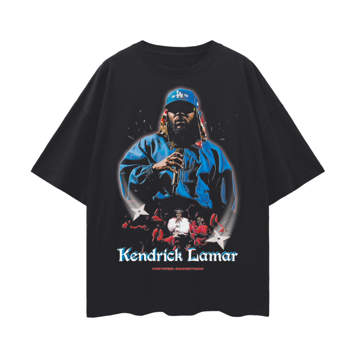A black oversized tee featuring Kendrick Lamar in a blue jacket and LA Dodgers cap, holding a microphone, with a powerful stage presence. The text 'Kendrick Lamar' is displayed below the image in stylized font.