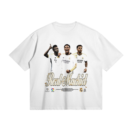 The front of the white oversized t-shirt showcases Jude Bellingham, Vinícius Jr., and Rodrygo in their Real Madrid jerseys, with "Real Madrid" written in elegant gold text beneath them.