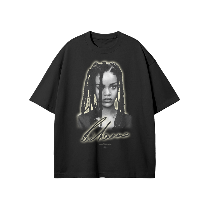 A black oversized t-shirt featuring a grayscale portrait of Rihanna with her signature below. The design has a soft glow effect around the portrait, adding a subtle highlight to the image.