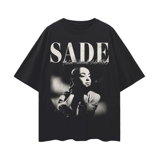 Black unisex oversized t-shirt with a black-and-white image of Sade resting her chin on her hand, overlaid with bold “SADE” lettering and her full name in script above the graphic.