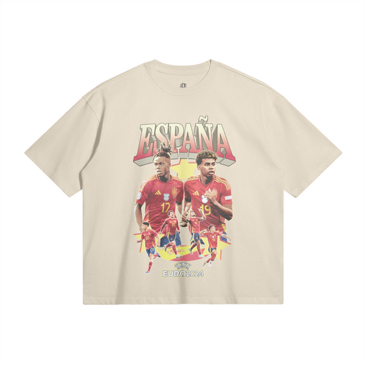 A beige oversized t-shirt showcasing two prominent Spain national soccer team players in the center, surrounded by additional players in action. The text "España" is displayed in large, stylized letters above the players, with the UEFA Euro 2024 logo at the bottom.