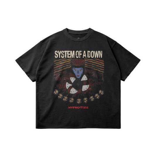 A black oversized t-shirt featuring the "System of a Down" logo at the top in distressed white lettering. Below, there is an abstract design with a central figure with a blue face and red hair surrounded by rotating clock hands. The bottom of the graphic displays the word "HYPNOTIZE" in red text.
