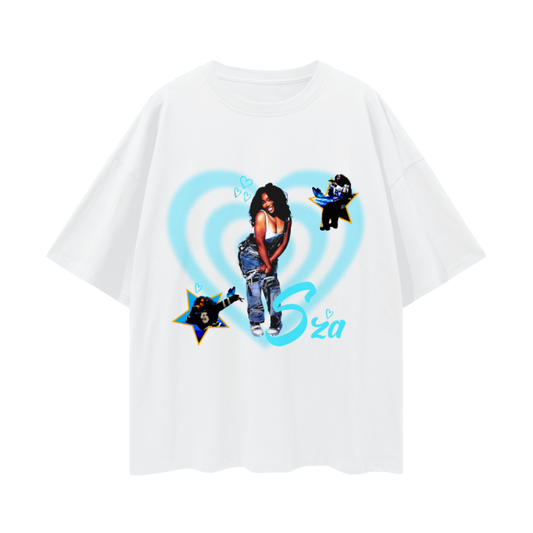 A white oversized t-shirt featuring a collage of the artist SZA in the center, surrounded by blue hearts. The design includes two smaller images of SZA inside yellow stars, positioned on the left and right sides of the shirt. The name "SZA" is written in a playful blue font near the bottom right of the design.